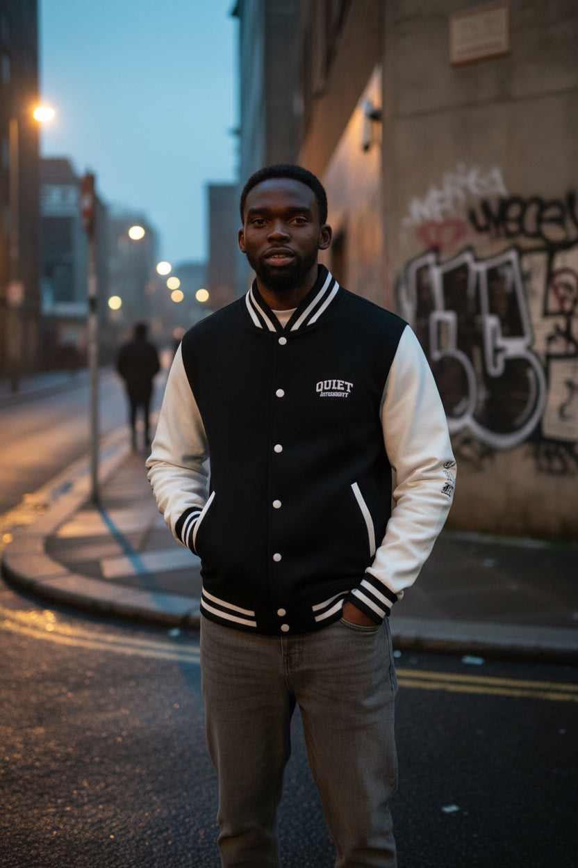 Craftklart UK underground varsity jacket by Printify featuring retro letterman style and streetwear design, displayed on a hanger.