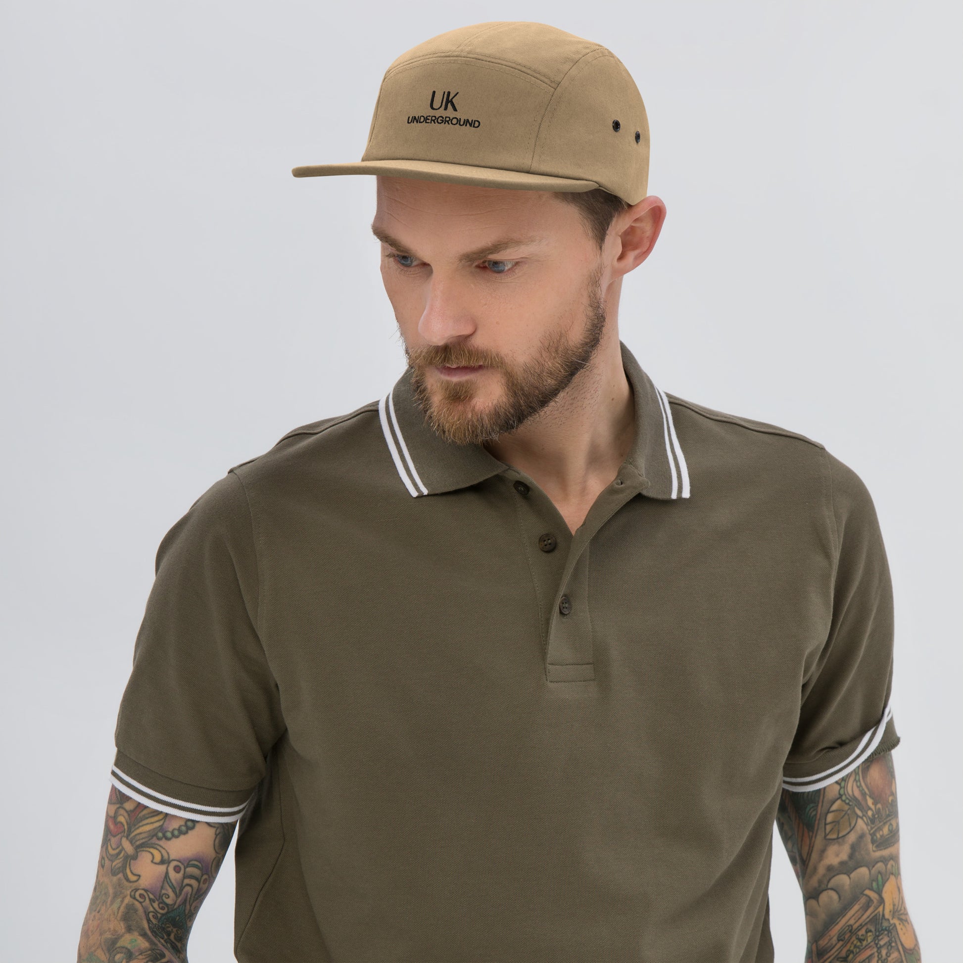 Khaki UK Underground five-panel cap with adjustable strap, showcasing a trendy streetwear style and bold branding on the front.