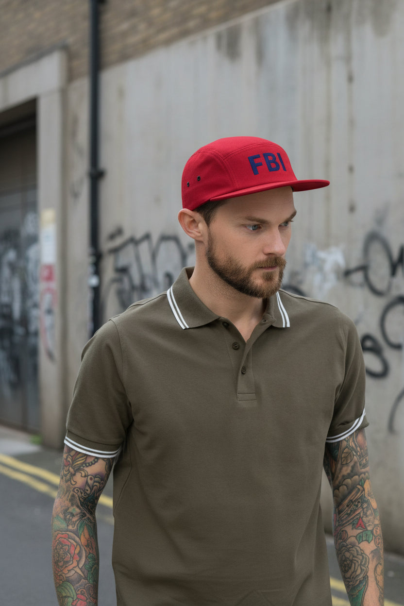 Red five-panel cap from Fashion Beyond Identity (FBI), Urban Fashion & Streetwear brand, showing front view with adjustable strap