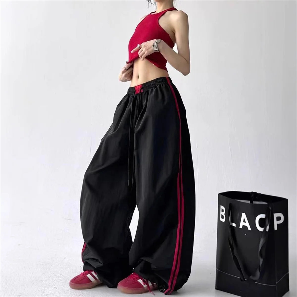 Women's wide-leg cargo joggers by Craftklart Dropship in red and black, featuring a Y2K streetwear style with baggy fit.