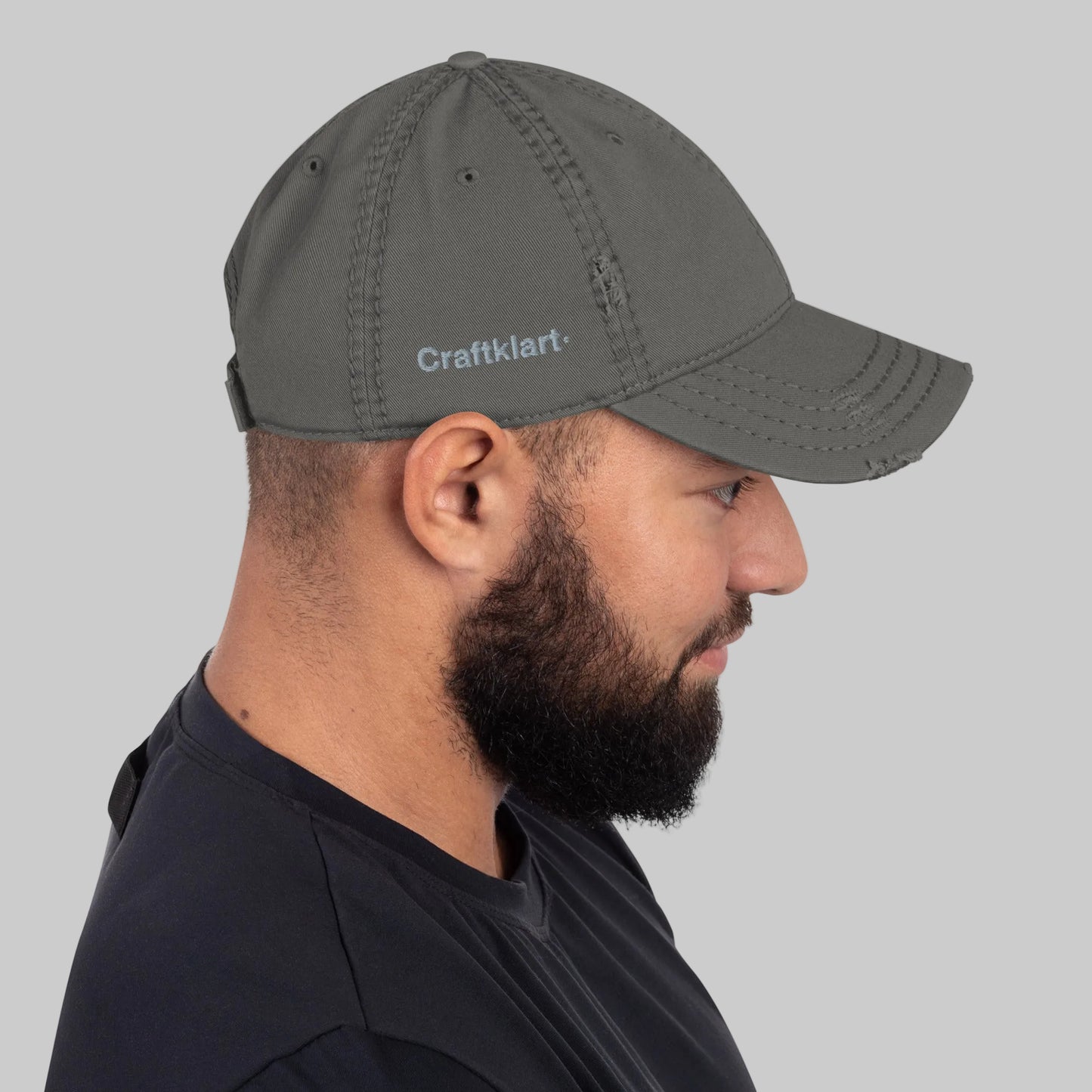 Craftklart distressed dad hat in charcoal grey, baseball cap style, shown from the right side with a faded, worn look.