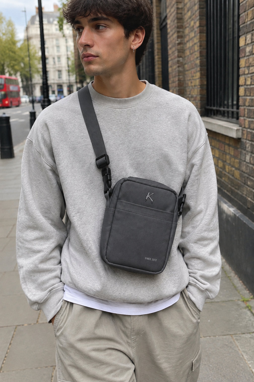 Black Printful K Utility Crossbody Bag, urban streetwear essential with adjustable strap and multiple compartments.