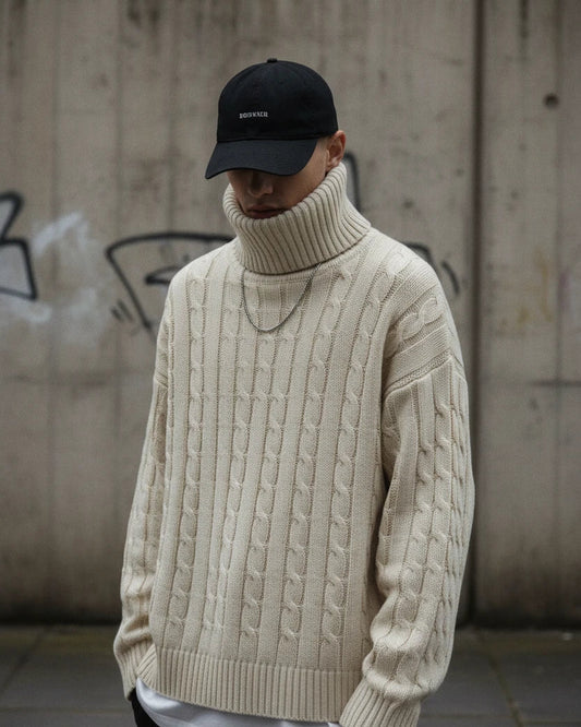 Urban Fashion & Streetwear | Craftklart cream cable knit turtleneck sweater worn by a man in a black baseball cap