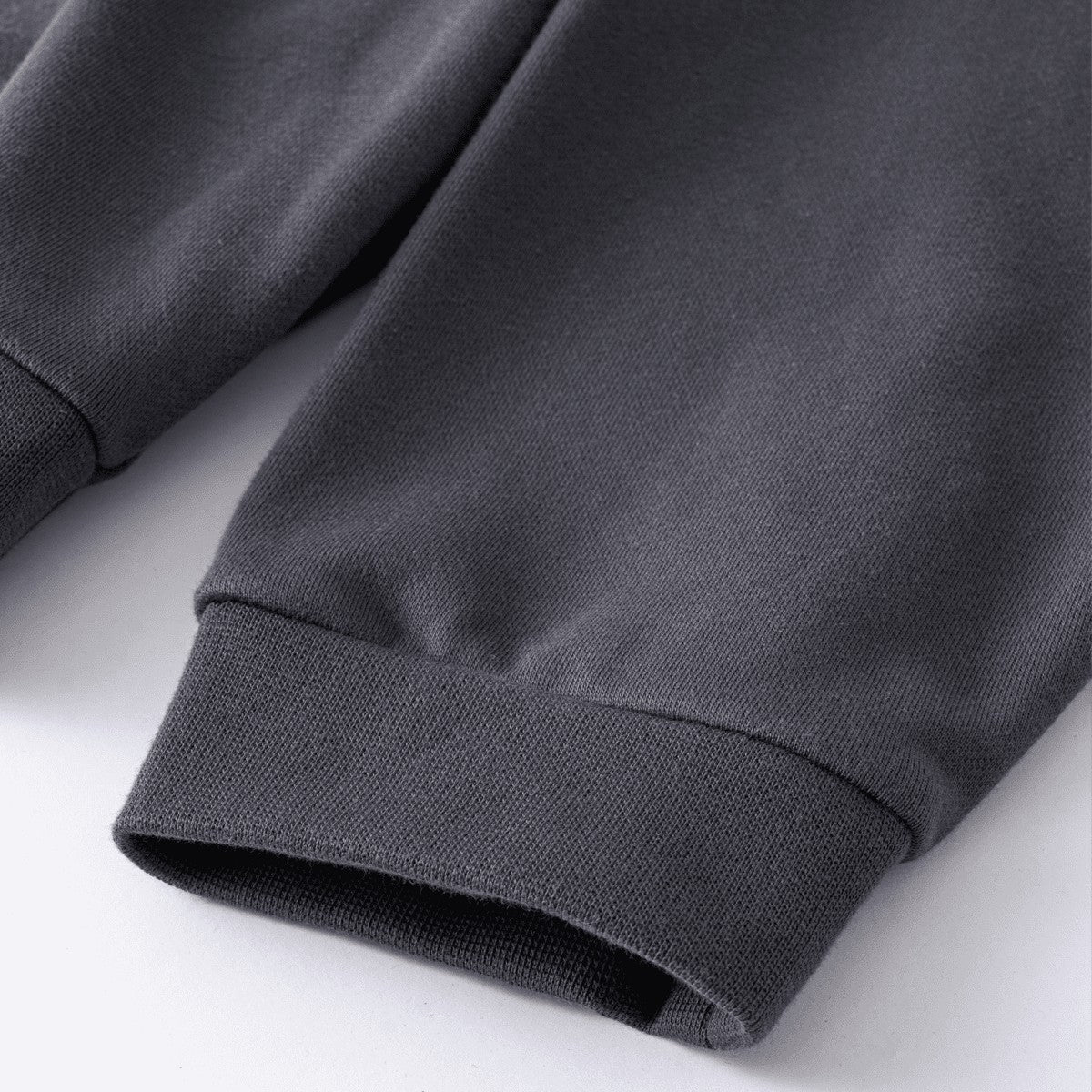 Close-up of the ribbed cuff on a dark grey Urban Fashion & Streetwear | Craftklart heavy cotton sweatshirt sleeve.