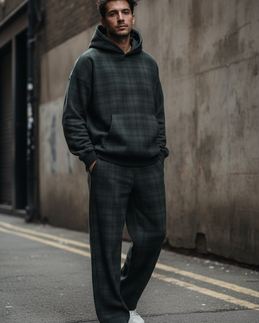 A man wearing Urban Fashion & Streetwear | Craftklart plaid straight leg trousers and matching hoodie in an alley.